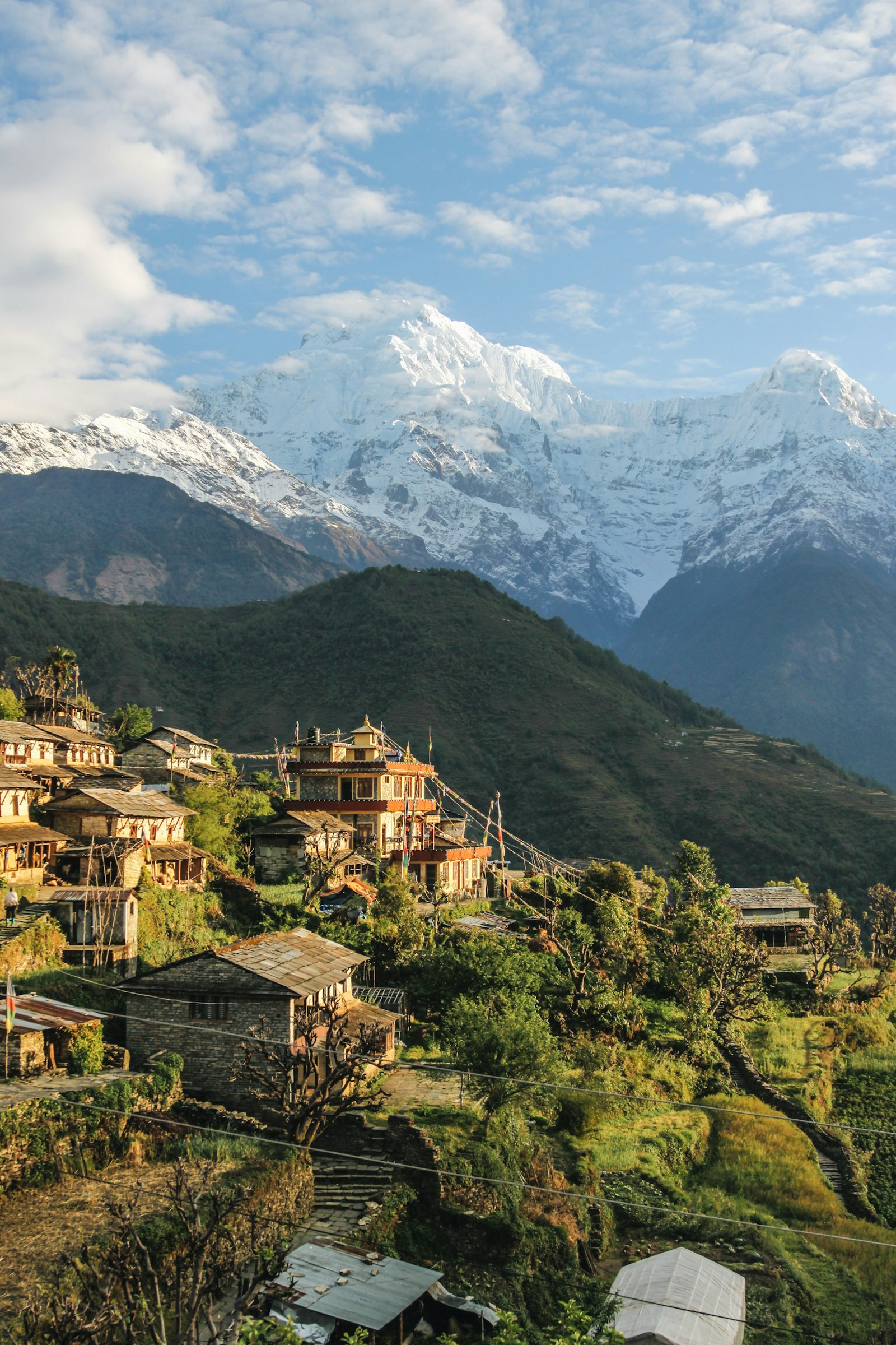Himalayan teahouse village with prayer flags and a snow peak, Nepal