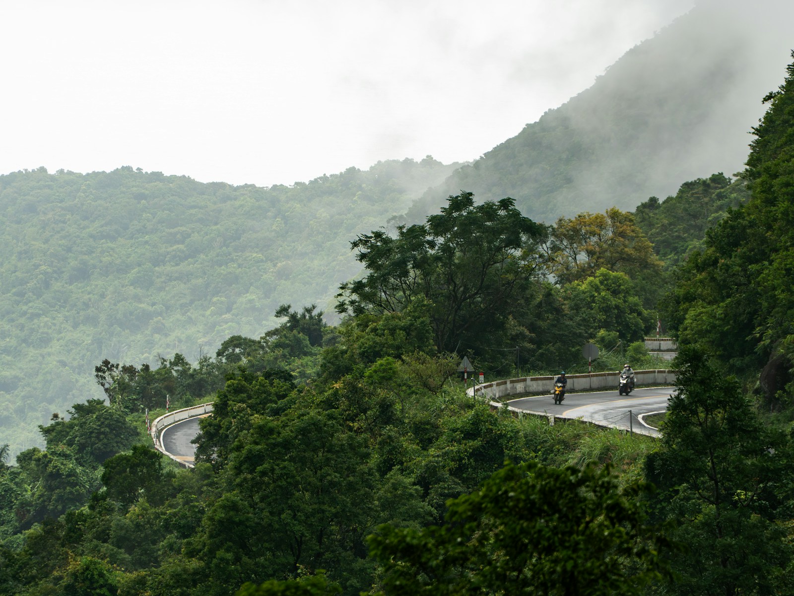 Motorcyclists on a misty hairpin, Hai Van Pass, Vietnam