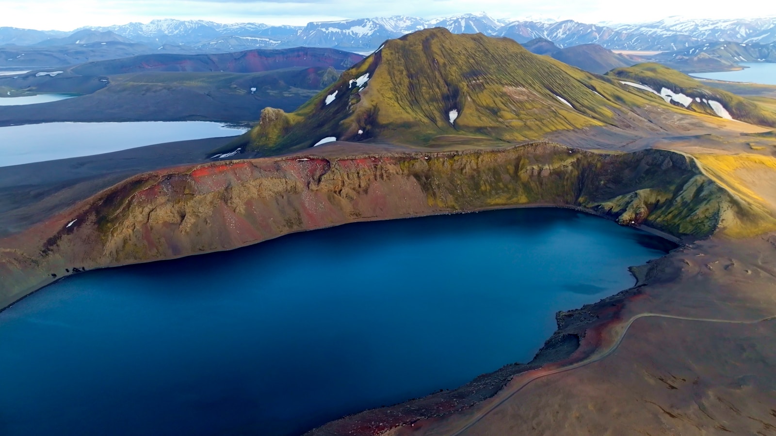 Blue crater lake ringed by rhyolite mountains, Iceland
