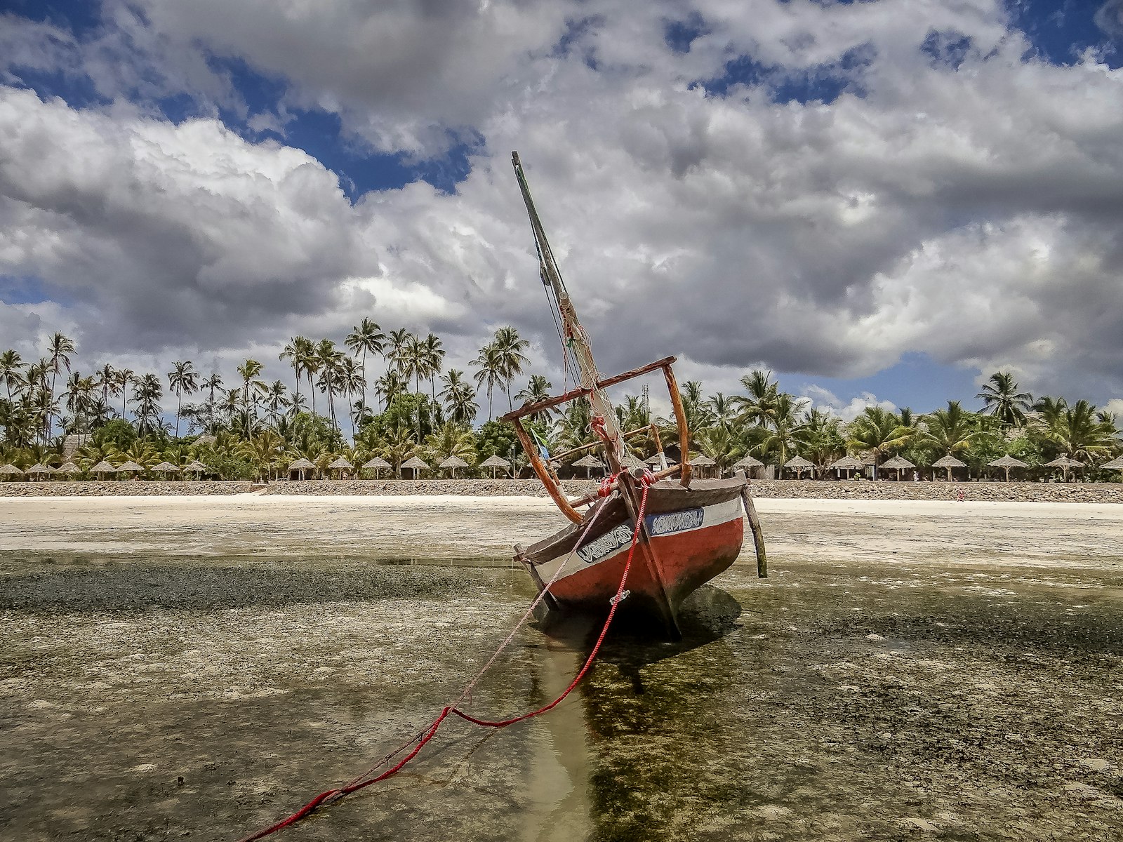 Dhow on a tidal flat by a palm beach, Mafia Island