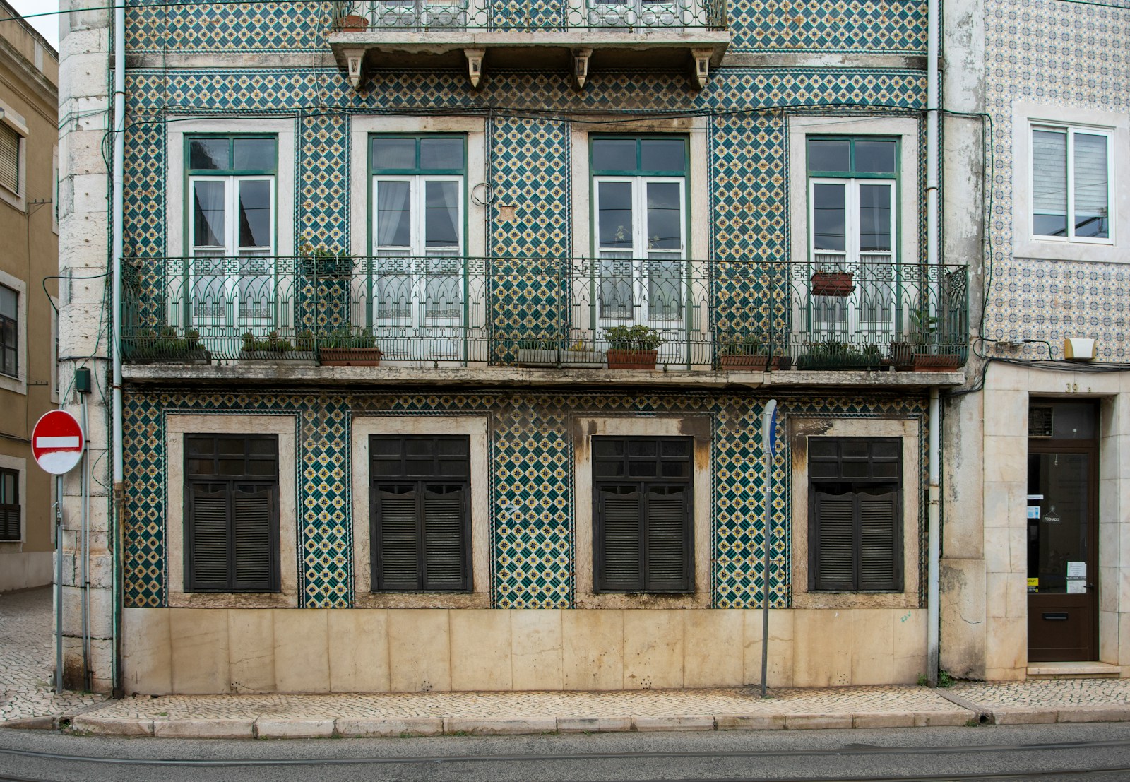 Azulejo-tiled Lisbon facade with tram tracks below