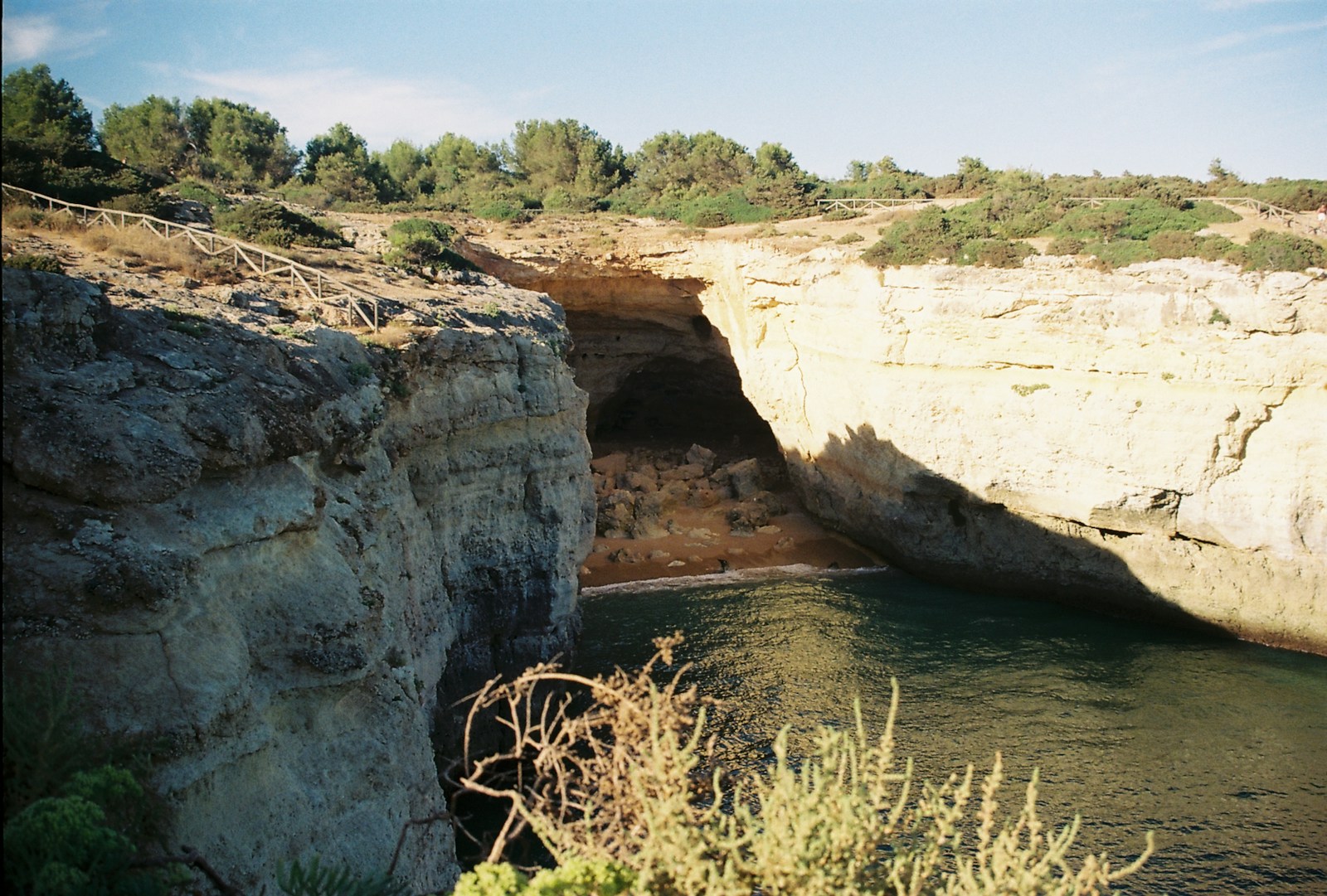 Sea cave in golden Algarve limestone cliffs