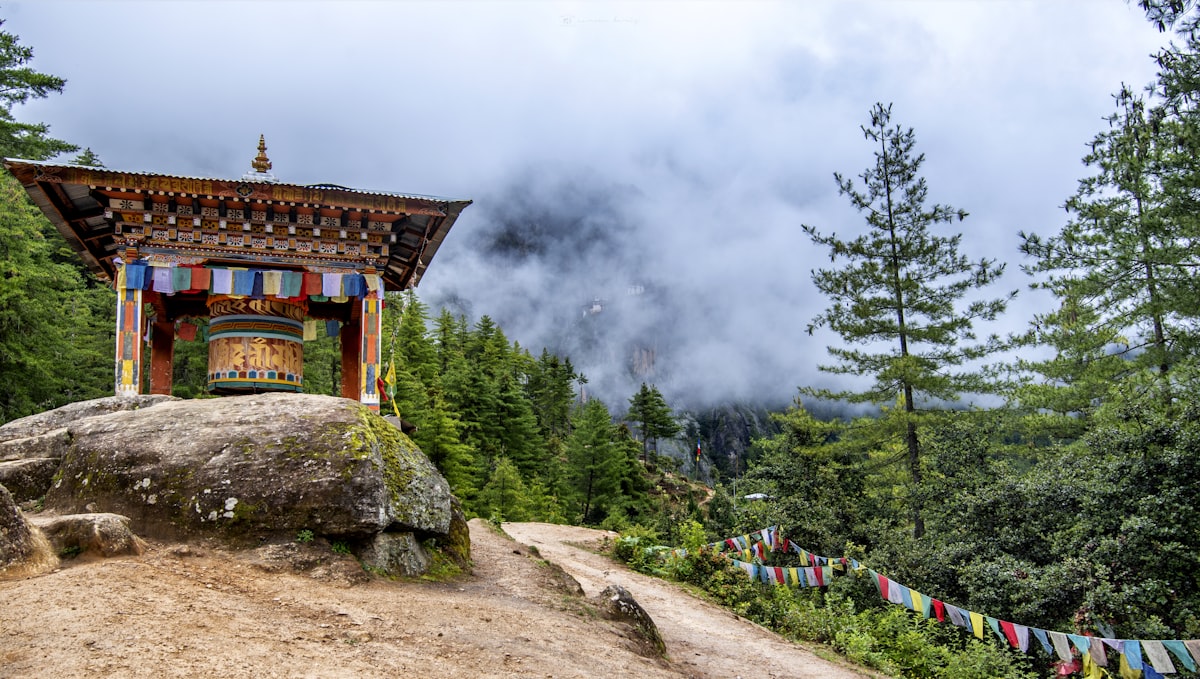 Prayer wheel and flags on the misty trail to Taktsang