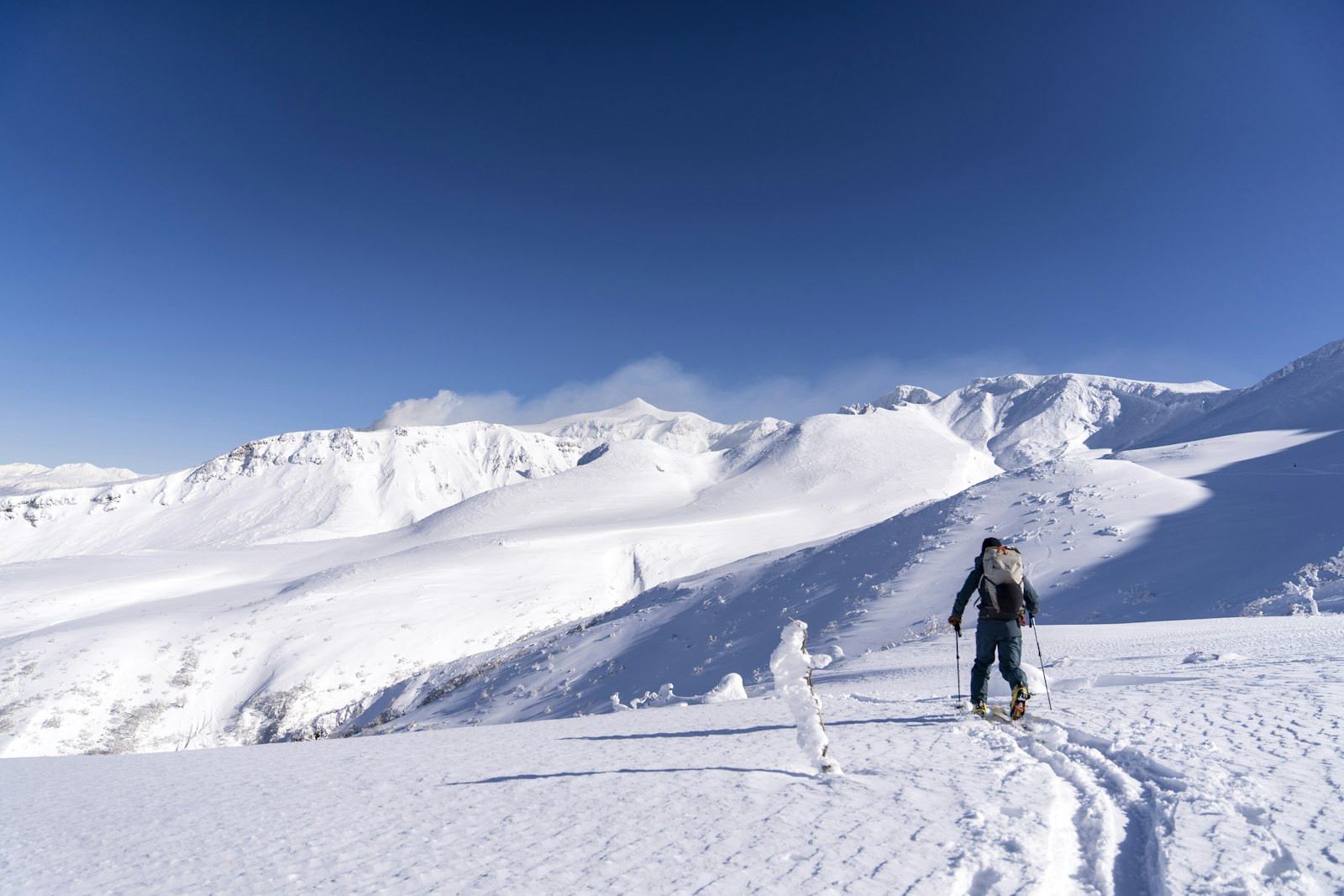 Ski tourer crossing a snow ridge in Daisetsuzan