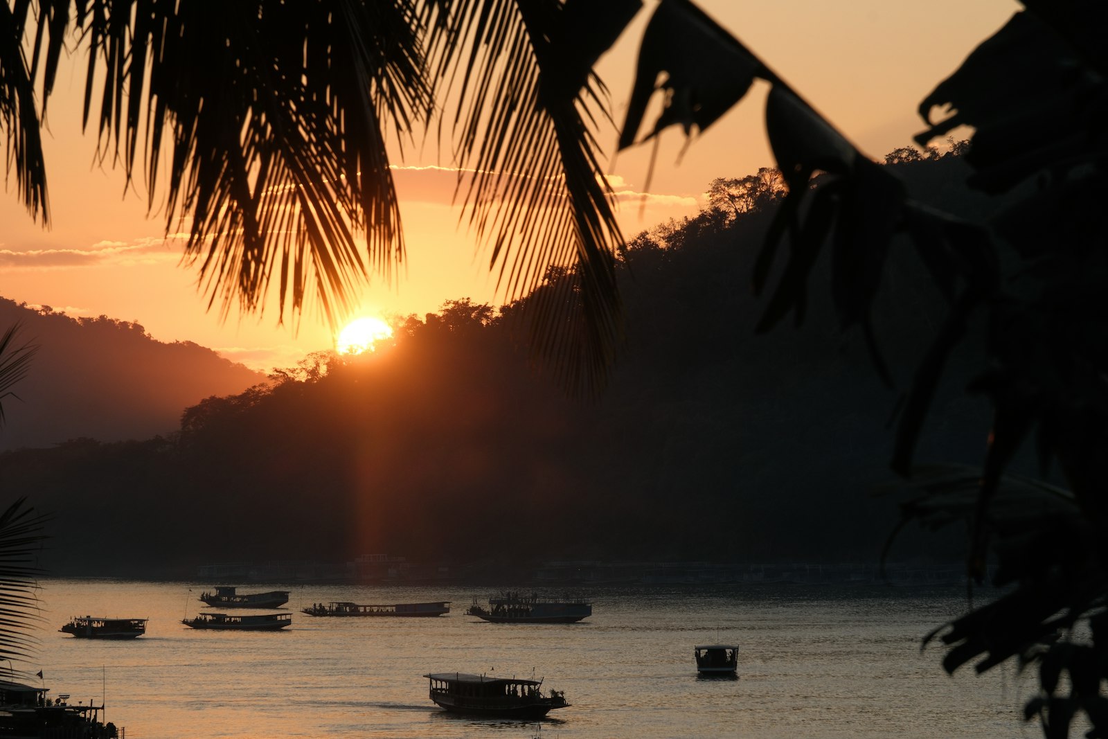 Traditional slow boats on the Mekong River at sunset